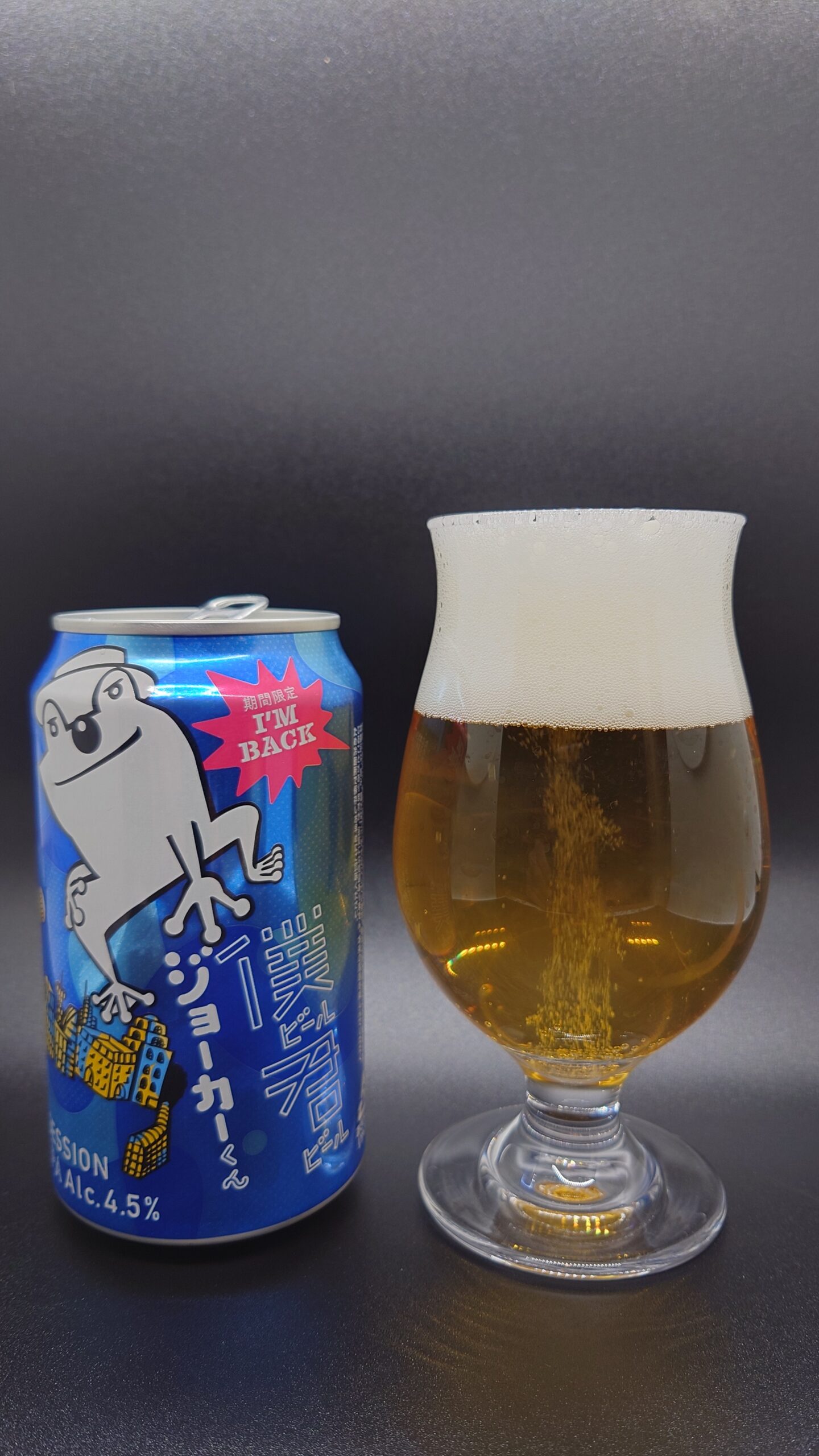 僕ビール君ビール ジョーカーくんの缶と、薄い黄金色のビールが注がれたチューリップグラスの全体写真。澄んだゴールドと泡立ちが特徴的。